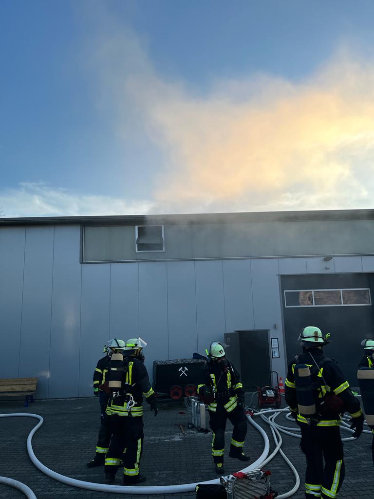 Feuerwehrleute bereiten sich auf einen Innenangriff in einem Industriegebäude vor