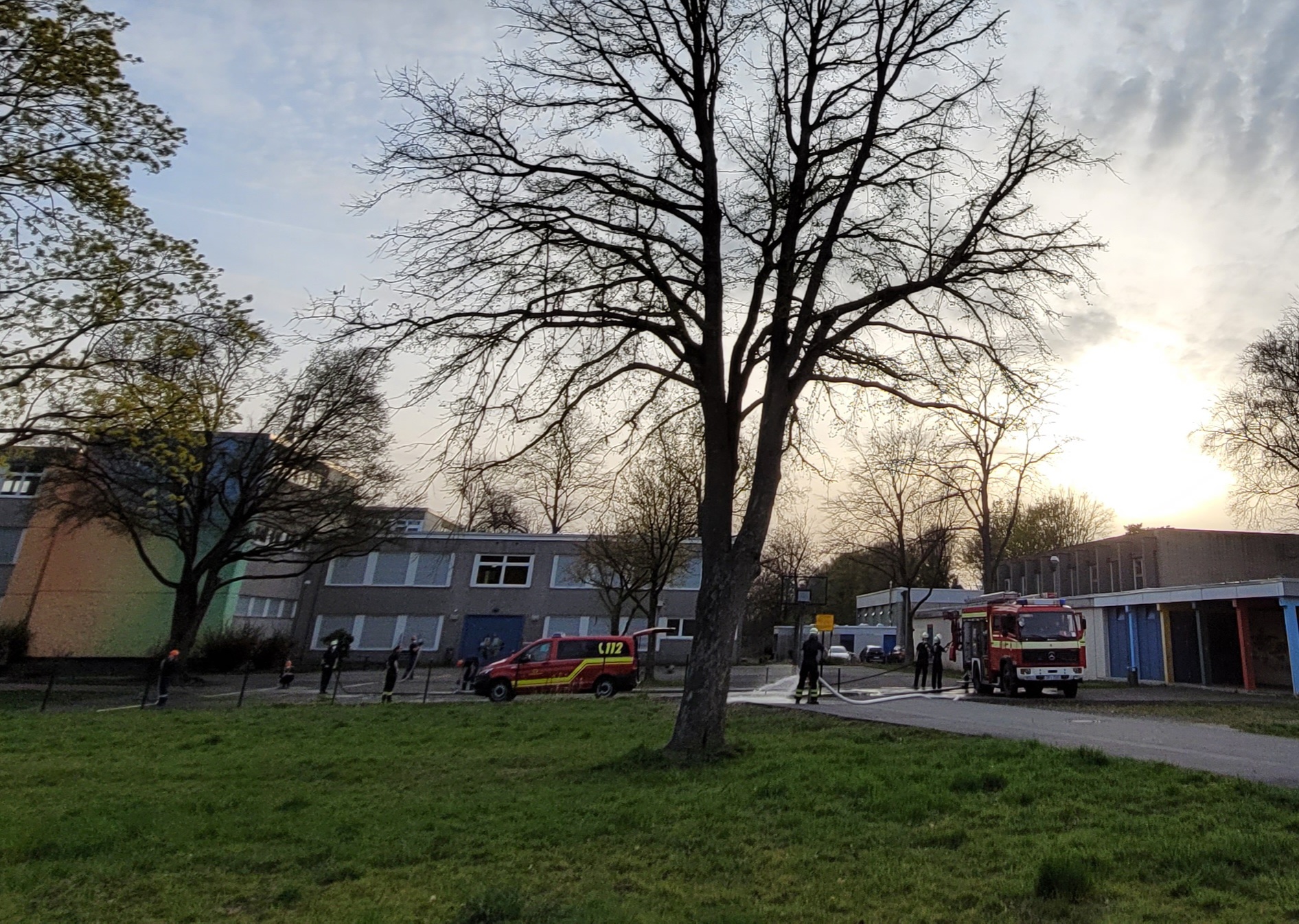 Feuerwehrfahrzeuge und Jugendfeuerwehrmitglieder auf dem Schulhof in Dortmund Sölde