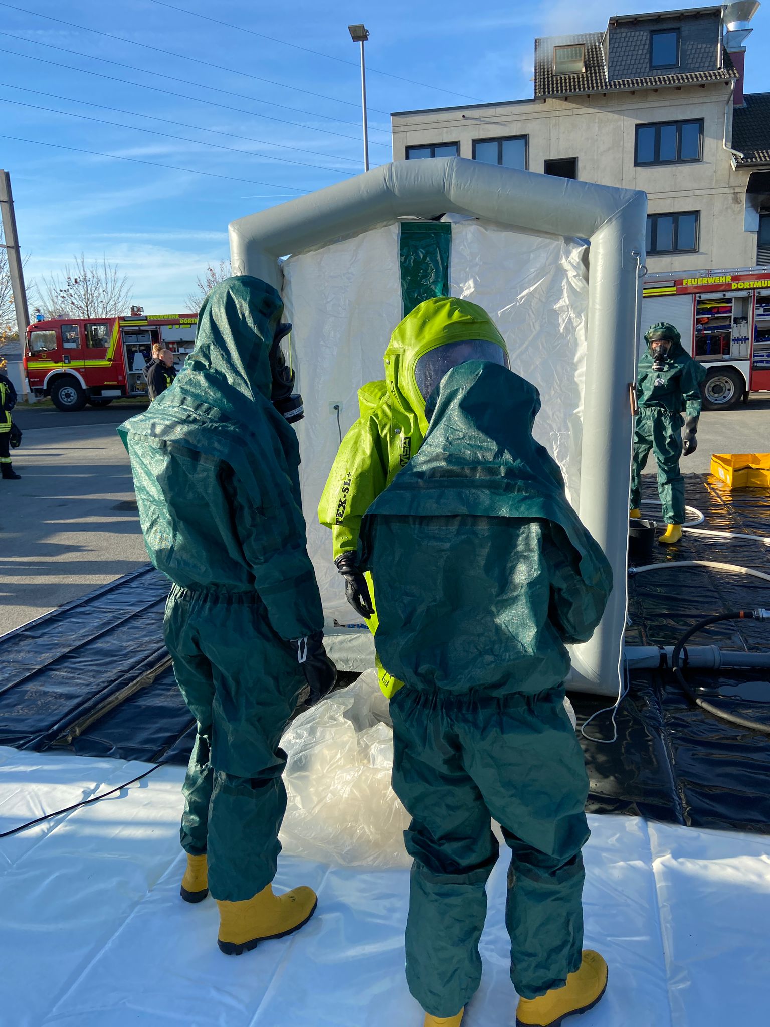 Feuerwehrleute in Schutzausrüstung bei der Dekontamination