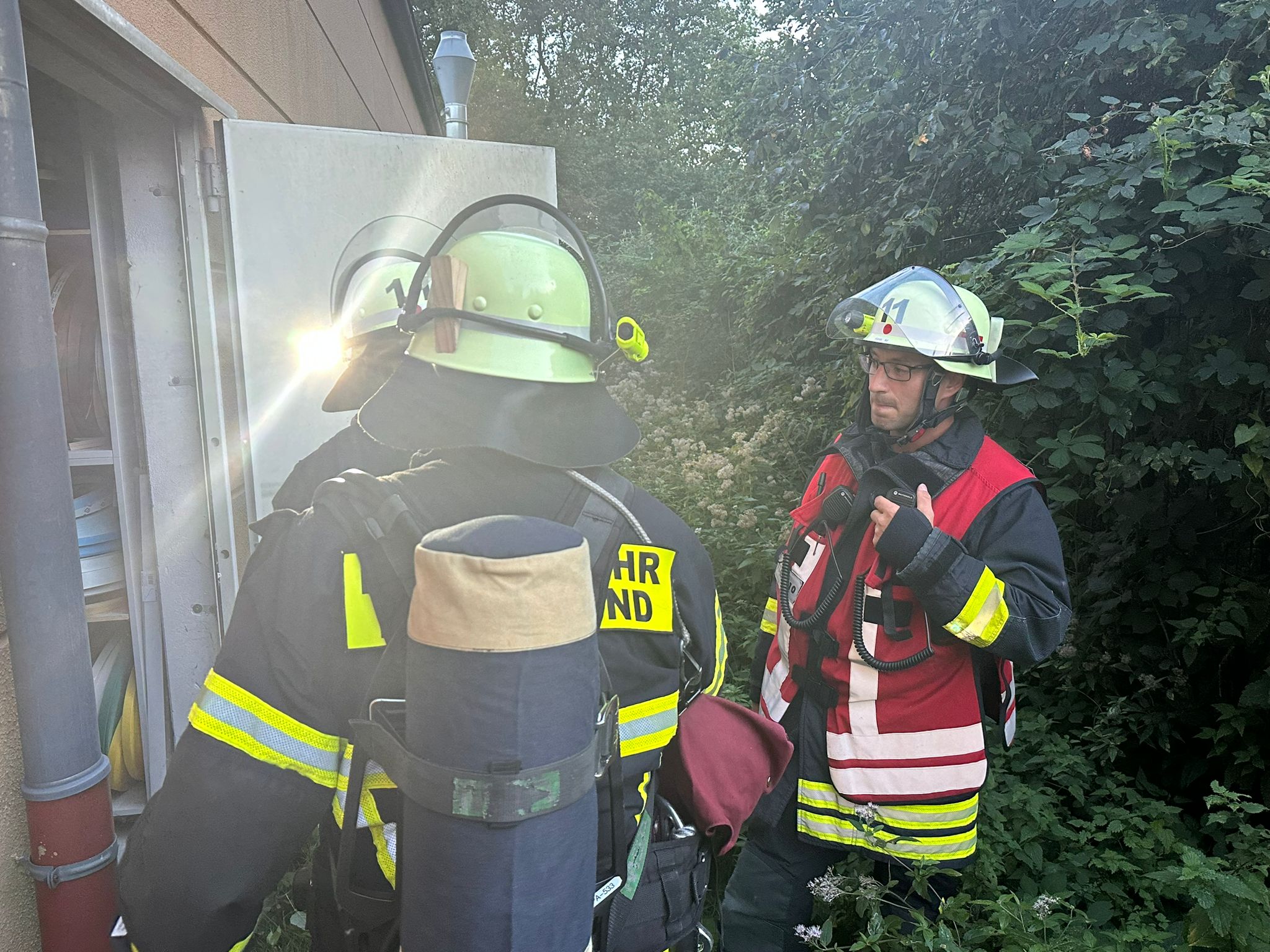 Ein Gruppenführer der Feuerwehr mit seinem Atemschutztrupp bei der Lageeinweisung