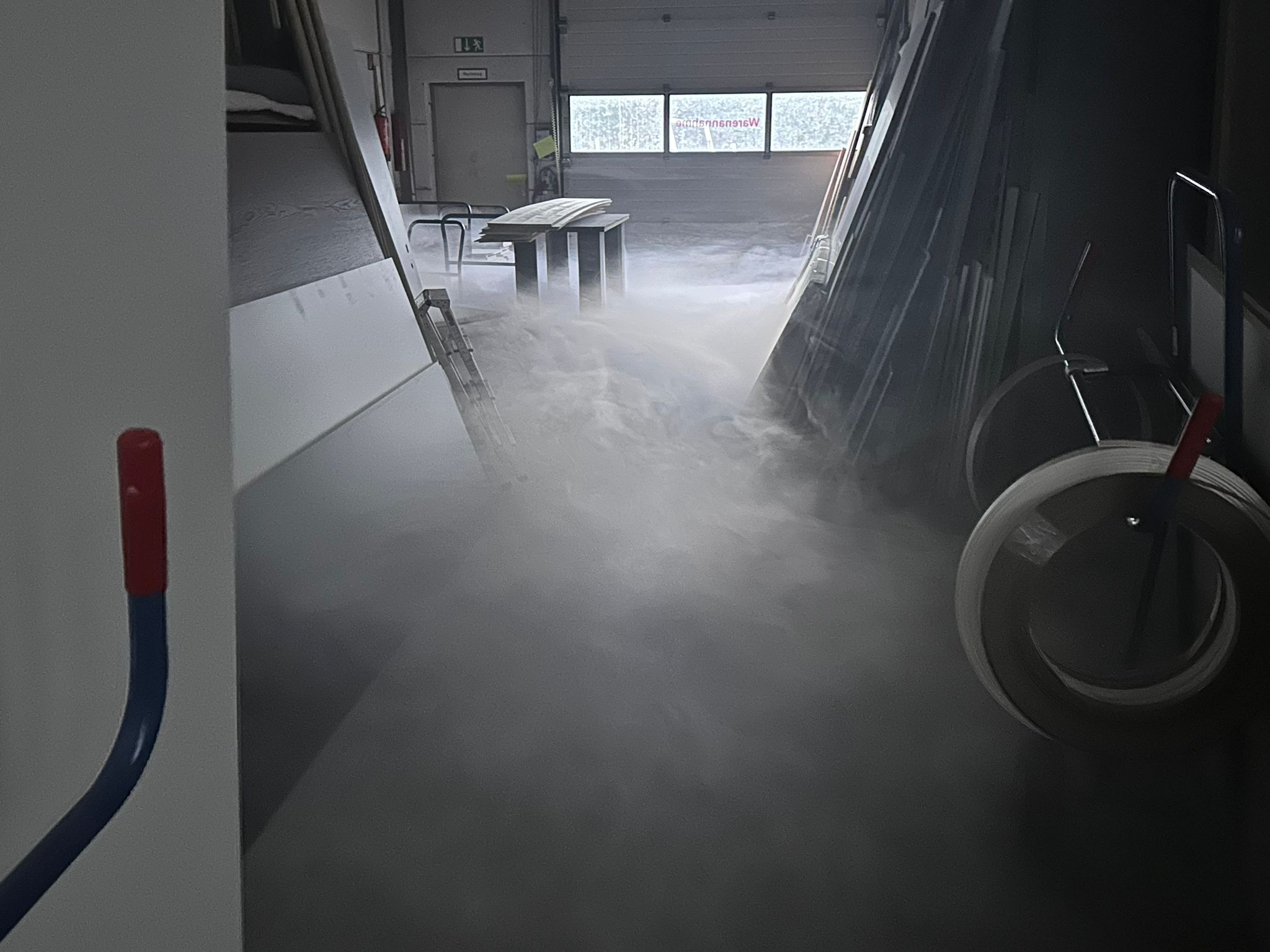 Rauch und Nebel kriechen über den Hallenboden einer Schreinerei